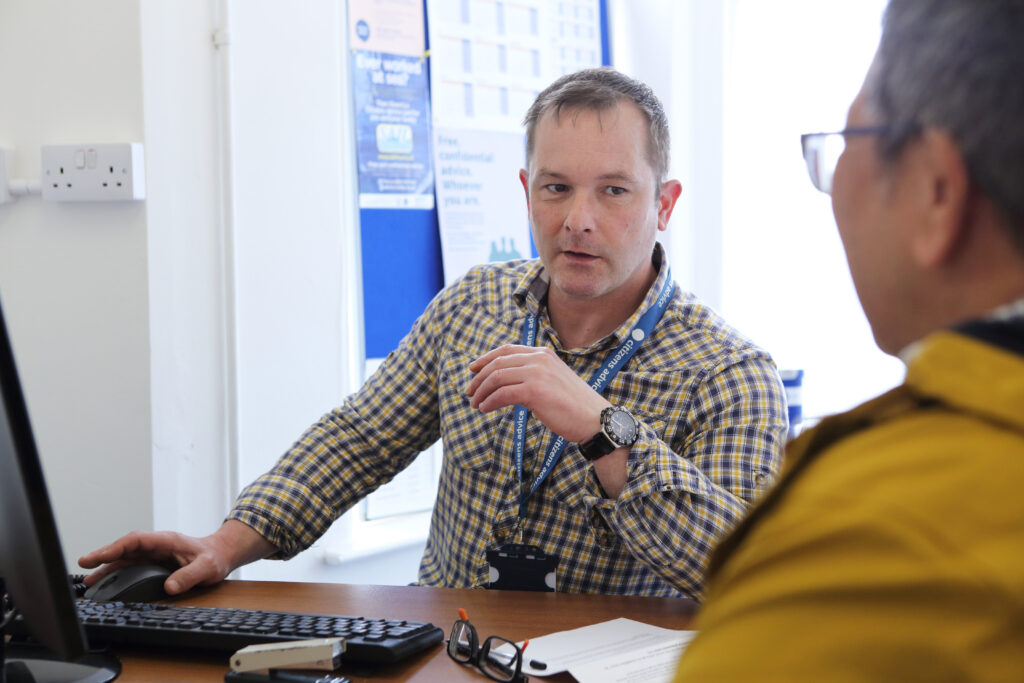 Male staff member talking with a colleague.